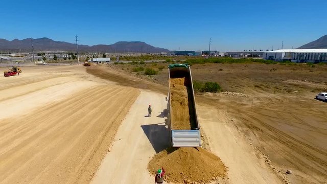 cami&oacute;n descargando tierra para Construcci&oacute;n de nave industrial con drone