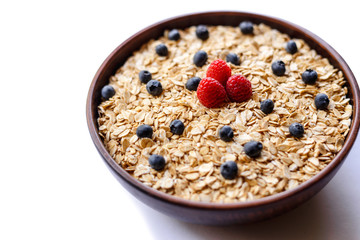 Oatmeal and fresh berries isolated on a white background.