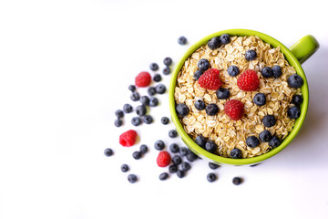 Oatmeal and fresh berries isolated on a white background.