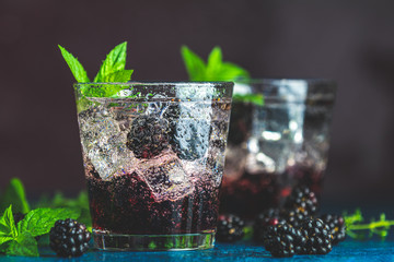 Cold summer berry drink with blackberries. Refreshing summer drink with syrup, blackberry and ice...