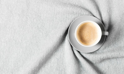 Winter cozy composition. Cup of coffee and warm knitted gray plaid. Flat lay, top view, copy space