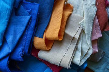 A stack of colorful fabrics background. Multicolored linen fabric