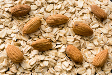 Background of oatmeal and almonds, flat view.