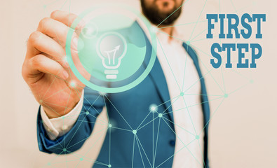 Conceptual hand writing showing First Step. Concept meaning Pertaining to the start of a certain process or beginning Male human wear formal suit presenting using smart device