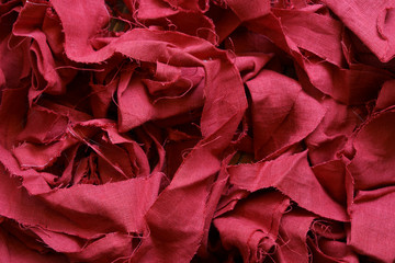 A pile of scraps of red linen fabric. Fabric background. Make clothes