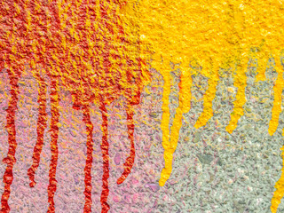 Brush strokes red and yellow paint drips on the outdoor concrete wall texture background