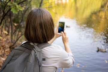 Woman taking a picture with a smart phone outdoors