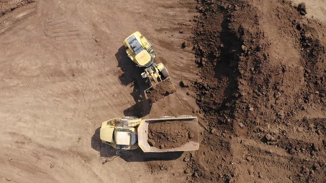 Excavator loading soil onto an Articulated hauler Truck, Top down aerial image.