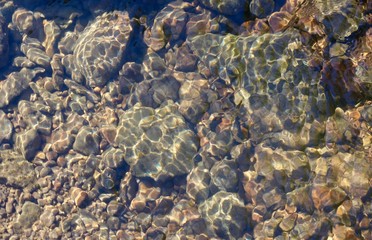 The rocks and the stone in the ripples of the clear water.