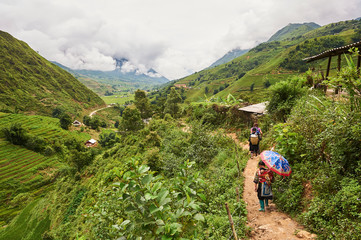 Naklejka premium A young mother Black Hmong with baby walking in Muong Hoa Valley, Sa Pa (Lào Cai province,Vietnam)