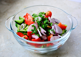 Tomato and cucumber salad with red onion, black pepper and parsley. Vegan food. Diet menu. Top view. 