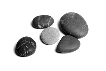 Scattered sea pebbles. Heap of smooth gray and black spa stones isolated on white background