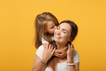 Woman in light clothes have fun with cute child baby girl 4-5 years old. Mommy little kid daughter isolated on yellow background studio portrait. Mother's Day love family parenthood childhood concept.