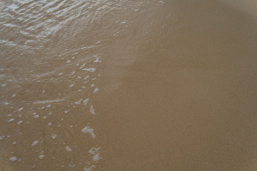 Beautiful waves rolling up on a sandy beach. Summertime in Österlen, Sweden.