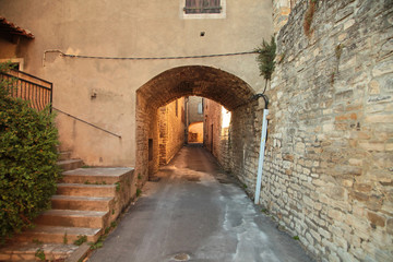 Narrow street with stone pavement of old town of Barjac. European old town at sunset, south France