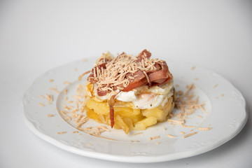 Spanish tapa, potato, fried egg, bacon and foie