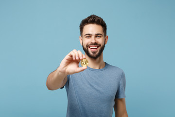 Young smiling handsome man in casual clothes posing isolated on blue wall background, studio...