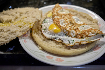 arepa with a fried egg topping it on a white plate