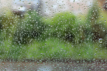 Raindrops on the window. Drops of water or rain drops on window glass with blur buildings background.