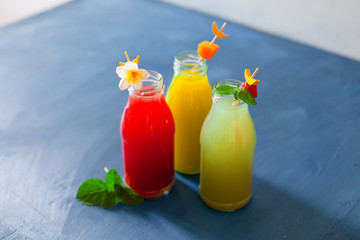 Fototapeta na wymiar Fresh fruit, berry and vegetable juices on bright blue background.Homemade refreshing beverage