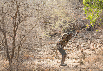hadzabe man hunting with his bow and arrows