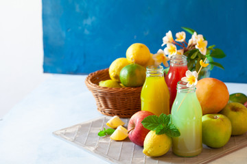 Fresh fruit, berry and vegetable juices on bright blue background.Homemade refreshing beverage