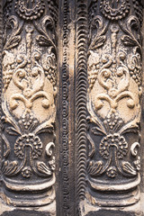 Ancient columns with Renaissance bas-reliefs and plants patterns in the wall