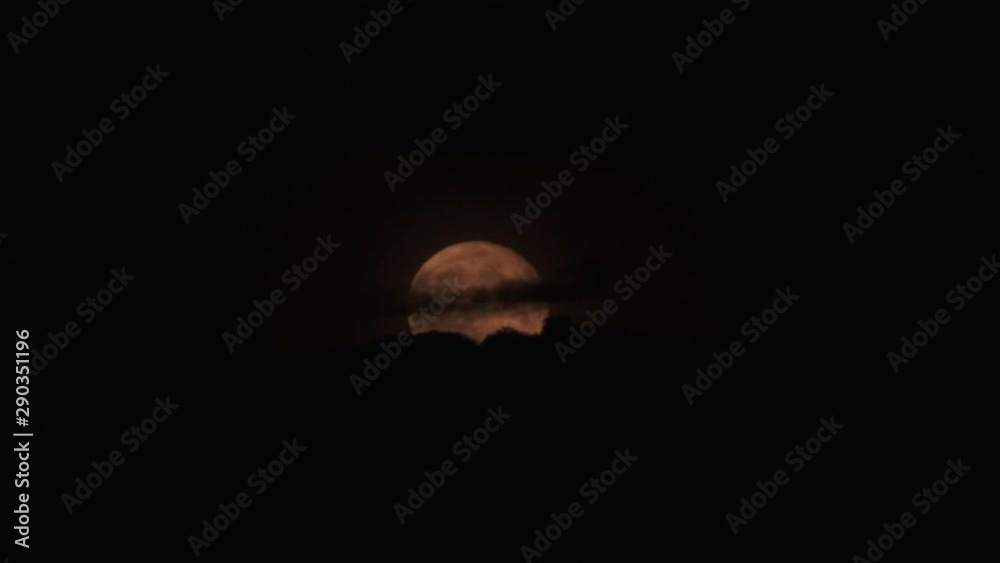 Wall mural timelapse warm glowing full moon rise and cloudy sky