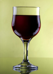 glass of red wine isolated on yellow background