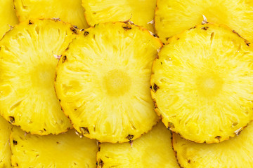 Sliced ripe pineapples pieces lay in pattern