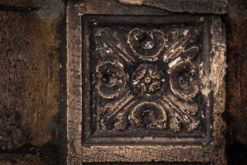 Ancient columns with Renaissance bas-reliefs and plants patterns in the wall