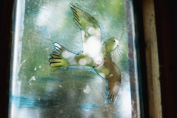 Dove painted on a glass window. Religious concept.