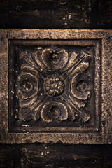 Ancient columns with Renaissance bas-reliefs and plants patterns in the wall