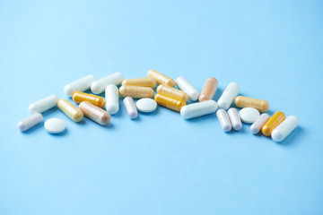 Vitamins and supplements on bright paper background. Concept for a healthy dietary supplementation. Close up. Copy space. 