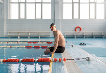 Athletic swimmer on poolside alone
