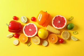 Different vegetables and fruits on yellow background, top view