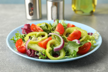 Salad of fresh vegetables on grey background, close up