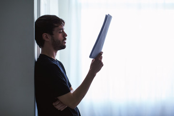 Young man reading script at home.