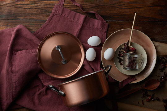 copper pan on a red apron with eggs