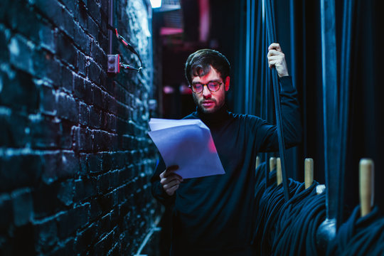 Actor reviewing script in theatre.