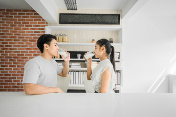 A handsome young man and beautiful young woman drinking milk in the morning, A 24s handsome male and 24s beautiful female  drink milk in the morning