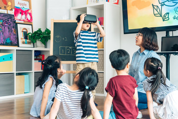 Preshool kids wearing virtual reality headset in classroom