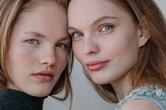 Beauty portrait of two pretty  blond girlfriends looking at camera