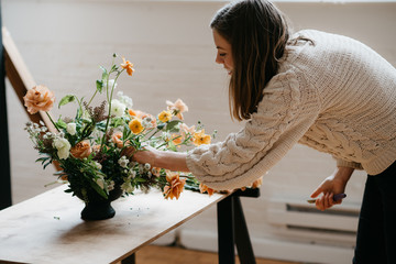 Florist in studio building a stunning floral arrangement