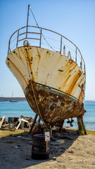 ein verrostetes Schiff am Strand