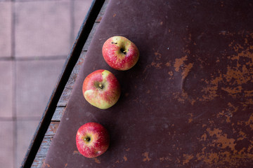 three apples on claret background