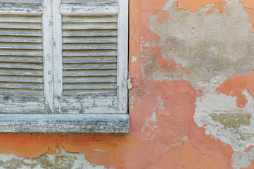 Window shutters in weathered house wall