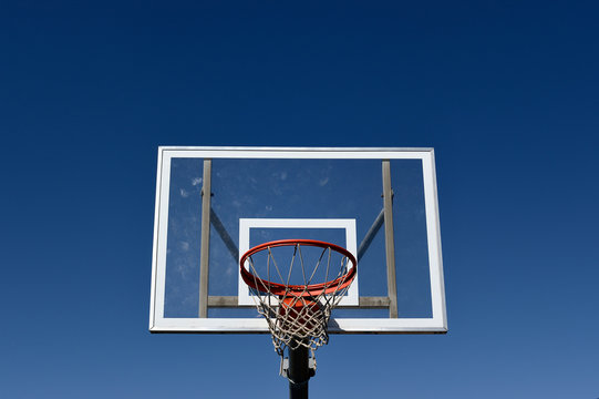 Basket ball hoop and backboard against a blue sky
