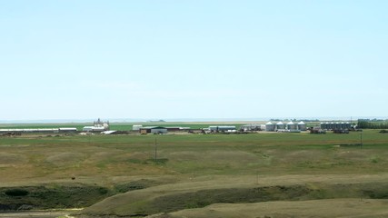 Wide zoom in on a Hutterite colony showing the buildings and farming equipment in this self-sustaining religious community.