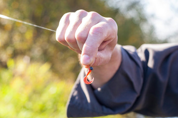 Fisherman holding a bait on the hook